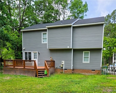 Back of property featuring a wooden deck, a yard,