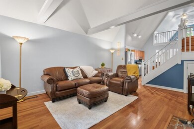 Living room featuring beamed ceiling, high vaulted