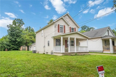 View of front facade with covered porch, a storage unit, crawl space, and a front lawn