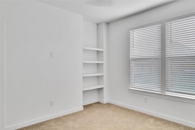Carpeted empty room featuring baseboards