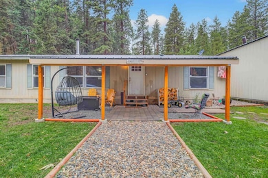 View of front facade with a metal roof, a front yard, and entry steps