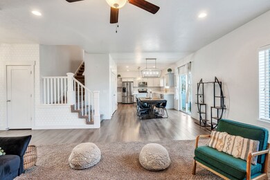 Living room featuring light wood-style flooring, stairs, ceiling fan, recessed lighting, and wallpapered walls