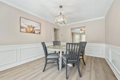 Dining area with ceiling fan with notable chandeli