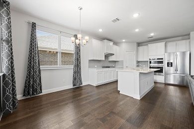 Kitchen featuring white cabinetry, appliances with