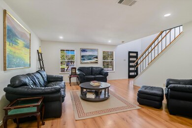 Living area with stairs, wood finished floors, an