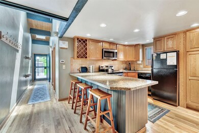 Kitchen featuring black appliances, light wood-sty