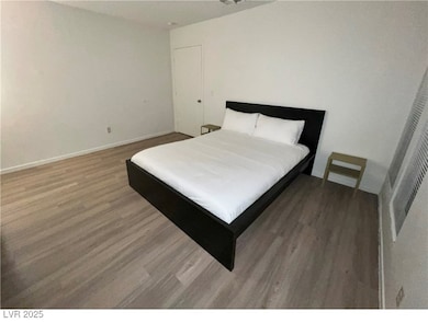 Bedroom featuring wood finished floors and baseboards