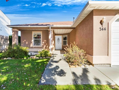 Property entrance with stucco siding, a porch, and roof with shingles
