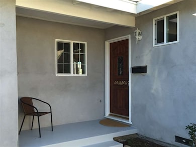 Front porch has a cute wood door with rose accents