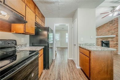Kitchen with black appliances, under cabinet range hood, light wood-style floors, a ceiling fan, and baseboards