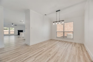 Unfurnished dining area with light wood-type flooring, a ceiling fan, a fireplace, and recessed lighting
