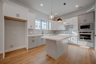 This modern kitchen features sleek cabinetry, stai