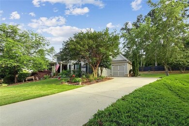 Obstructed view of property featuring driveway, a front yard, and a garage