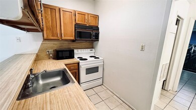 Kitchen with black microwave, white electric rang