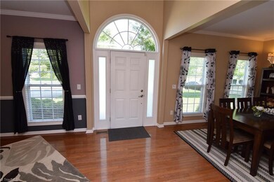 The sunny two story foyer opens to formal living and dining areas. Note the lovely hardwood floors!
