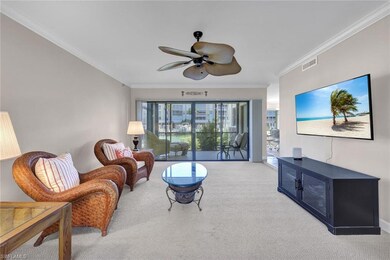 Living room featuring ceiling fan, crown molding, and light carpet
