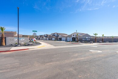 View of asphalt road featuring sidewalks, a residential view, curbs, traffic signs, and street lighting
