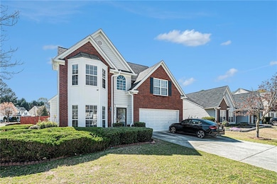 Traditional-style house featuring brick siding, driveway, a garage, and a front yard