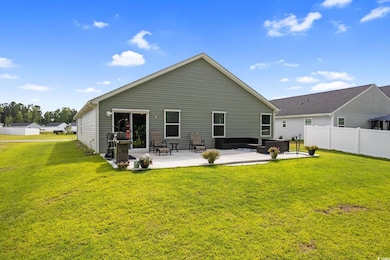 Rear view of property featuring a hot tub and a patio