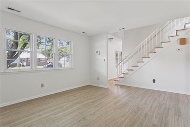 Unfurnished living room with stairway and light wood finished floors