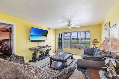 Carpeted living room featuring ceiling fan and a t