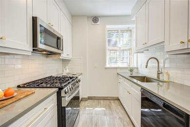 Kitchen featuring appliances with stainless steel finishes, a sink, light wood-style flooring, and white cabinetry