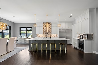 This stunning gourmet kitchen boasts a generously sized island, making it the ideal space for crafting delicious culinary masterpieces and hosting warm, inviting gatherings with family and friends.