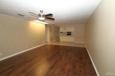 Unfurnished room with wood finished floors, ceiling fan, baseboards, and visible vents