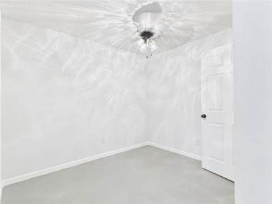 Empty room featuring concrete flooring and a ceili