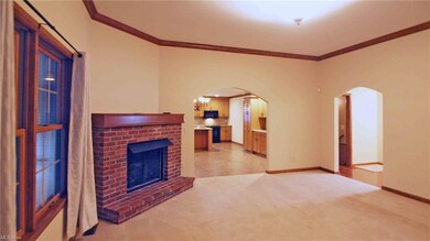 Living room with brick gas fireplace, window to su