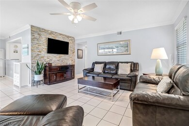 Tiled living room featuring crown molding and ceil