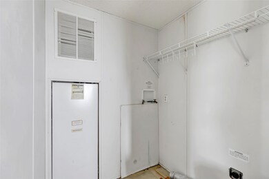 This photo shows a utility room with a white wall,