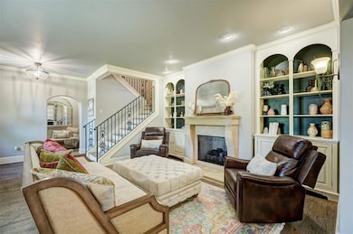 Living room featuring arched walkways, stairs, bui