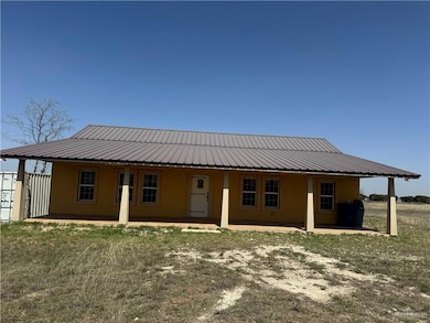 Rear view of property with stucco siding, metal roof, and a patio area