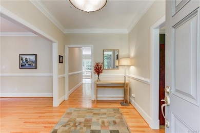 Front foyer with hardwoods, chair rail, crown mold