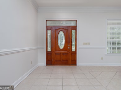 Beautiful grand entry with deep stained doors and bright natural lighting.
