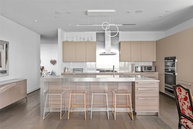 Designed by Eggersmann Kitchen & Home, the space features a complete Miele appliance package, a sleek Kuzco Chute Calypso LED light fixture, and integrated Savant surround sound, blending modern functionality with sophisticated style.