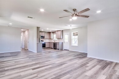 Unfurnished living room featuring ceiling fan, lig