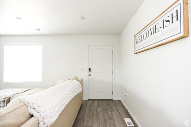 Bedroom featuring dark wood-type flooring and baseboards