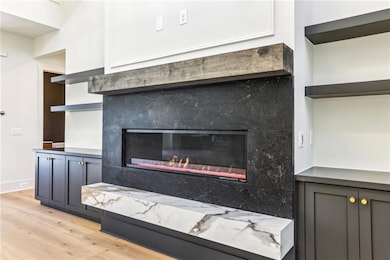 Detailed view of wood finished floors and a glass covered fireplace