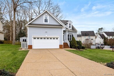 View of property featuring a front lawn and a gara