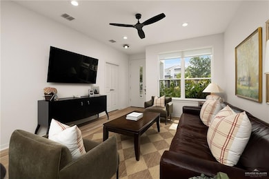 Living area with recessed lighting, a ceiling fan, and light wood-style floors