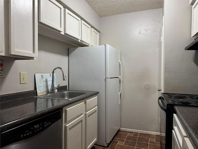 Kitchen with black / electric stove, dark countert