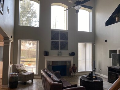 2 story family room with wall of windows featuring center fireplace.  Notice the gorgeous slate floors.