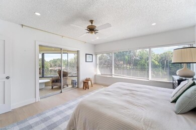 Bedroom with access to exterior, wood finished floors, a textured ceiling, baseboards, and recessed lighting