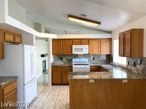Kitchen with white appliances, brown cabinets, vau