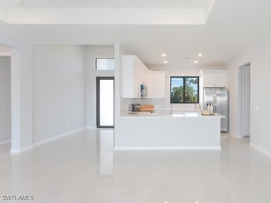 Kitchen with backsplash, white cabinetry, an islan