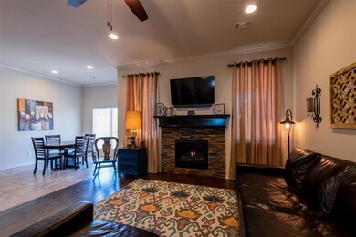 Living area with a ceiling fan, crown molding, a stone fireplace, recessed lighting, and baseboards