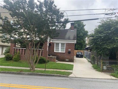 View of front of home featuring crawl space, brick siding, driveway, and a chimney
