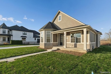 Craftsman-style house featuring brick siding, covered porch, and a front lawn